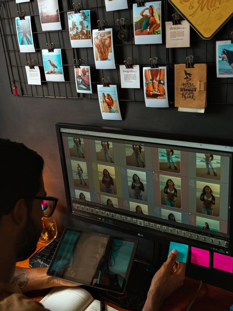 Editor working in a color grading suite with reference monitors and a grading control surface